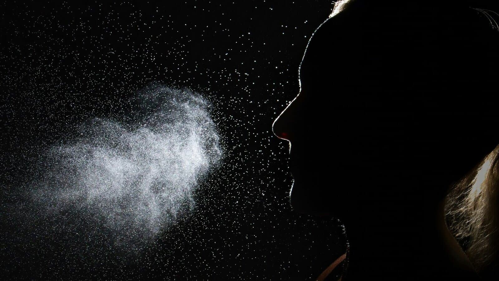 A backlit profile silhouette with a fine mist in the air, evoking intranasal administration of a short-acting psychedelic.
