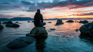 a man sitting near an ocean thinking about how psychedelic therapy works